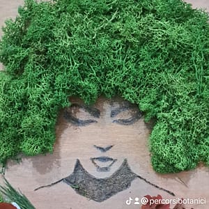 Volto di donna realizzato con pirografo e lichene stabilizzato, misure cm 50 x 60 circa