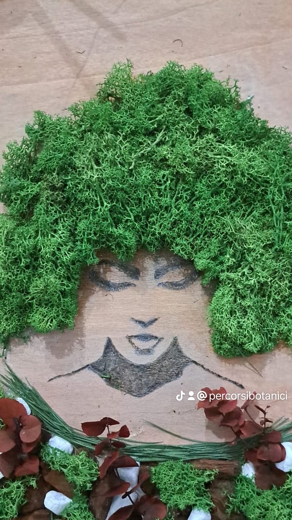 Volto di donna realizzato con pirografo e lichene stabilizzato, misure cm 50 x 60 circa